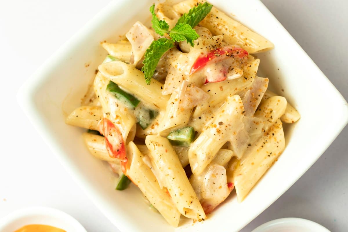 A bowl of penne pasta with sauce